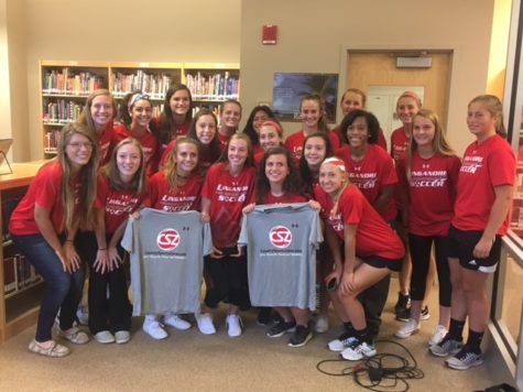 Varsity Girls Soccer team shows off Miranda Keaton's new shirts and award.