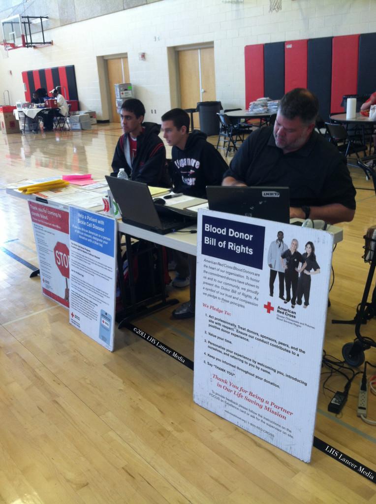 Jack Garabedian, Kyle Johnson, and Mr. Jeremy Brown work the sign-in table at the blood drive.