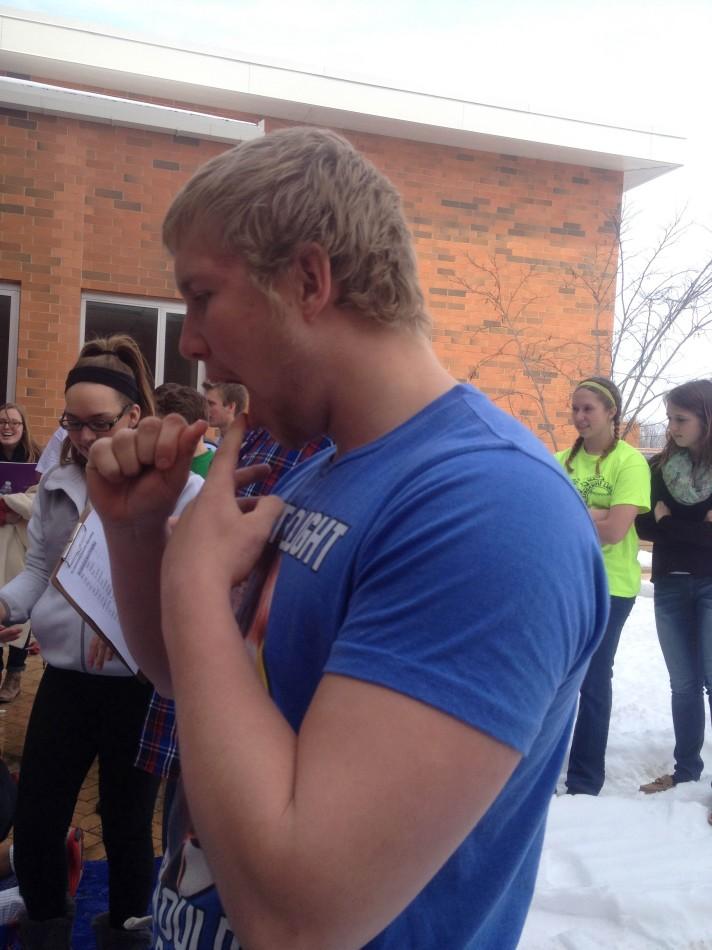 Luke Hubbard stretches his mouth in preparation to bob apples.