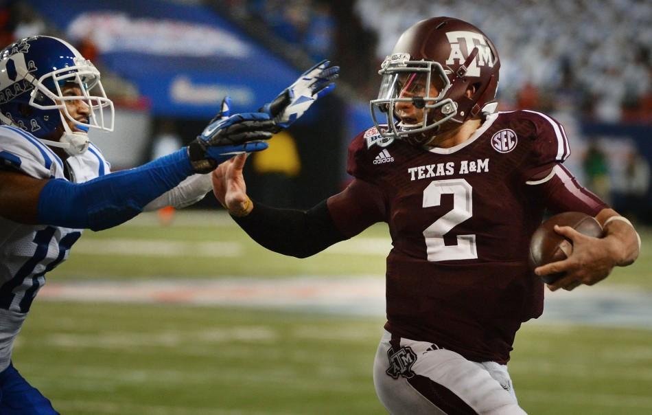 Texas A&amp;M Aggies quarterback Johnny Manziel (2) stiff-arms Duke Blue Devils safety Jeremy Cash (16) as he goes into score a fourth-quarter touchdown in the Chick-fil-A Bowl at the Georgia Dome in Atlanta on Tuesday, Dec. 31, 2013. The Aggies win, 52-48. (Photo courtesy of Chuck Liddy/Raleigh News &amp; Observer/MCT)
