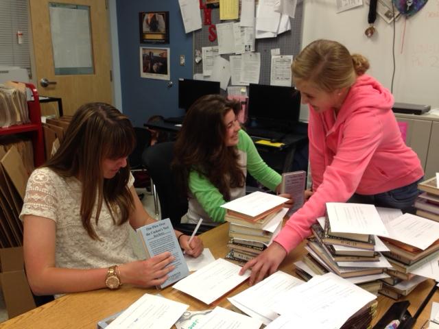 Elena Nicoll, Natalie Smith, Amy Safsten working on the AP Lit books that will be used in the coming school year.
