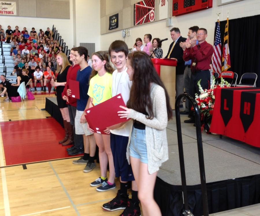 Students from each grade level line up after receiving a departmental award in business.