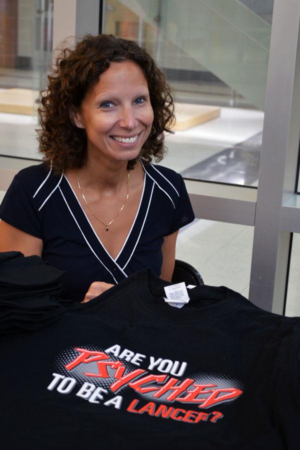Mrs. Blum sells freshman class t-shirts at lunch.