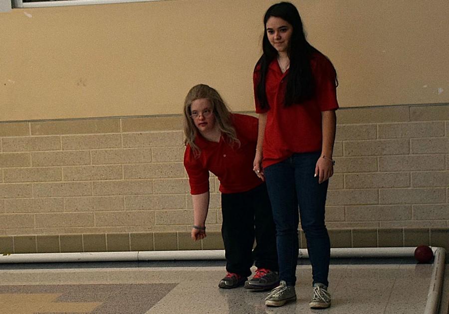 Michelle Weddle (right) helps Sarah Webber (left) throw the bocce ball at their match against Oakdale. 