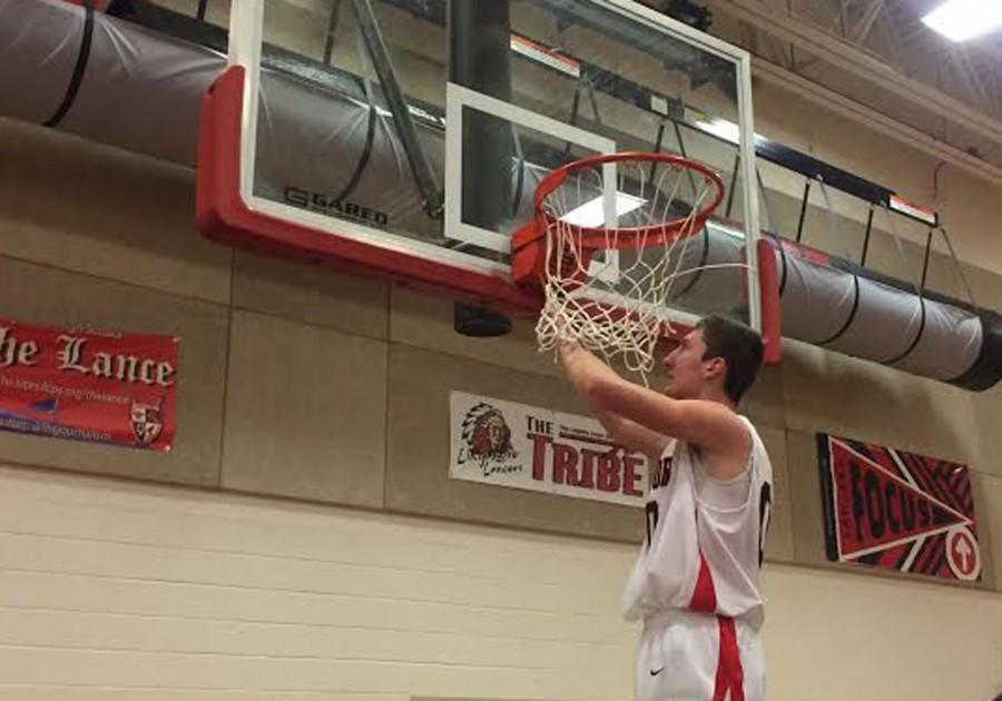 Thomas Lang cuts off a piece of the net, in honor of the teams regional win.
