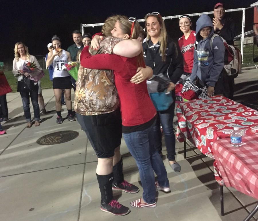 Taylor Wheelock hugs coach Jackie Sowers at the end ceremony on Senior Night
