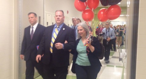 Mr. David Kehne and Miller's wife, Sue Miller, parade through the hallways to present the award.