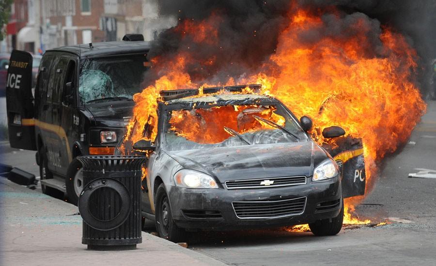 A Maryland Transit Authority patrol car burns at North and Pennsylvania Avenues on Monday, April 27, 2015, in Baltimore. (Jerry Jackson/Baltimore Sun/TNS)