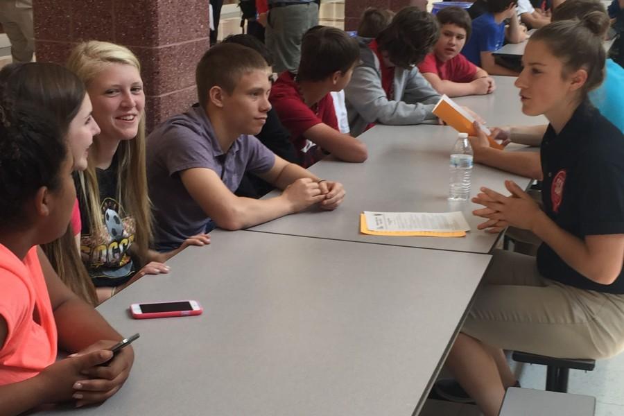 Kiley Gales, Haley Stone, Emily Byrnes, and Adam Cooper listen  to Emma Roerty at move-up day
