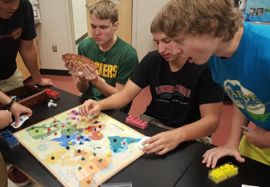 Left to right: Devin Kohn, Thad Engle, and Matt and Sam Honchalk play Risk in board games club.