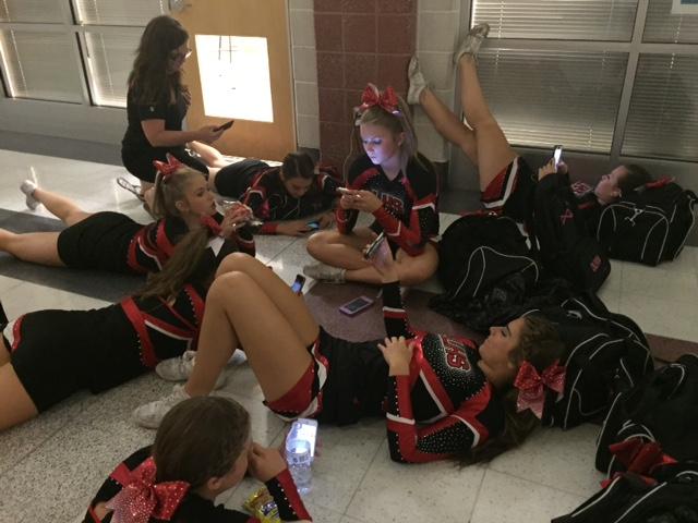 Cheerleaders Chloe Cline, Jordyn Bindel, Madelyn Howard, Jan Ingram, Nikki Ecott, Olivia Felton, and Olivia and Skyler Merritt wait inside the school building for storm to pass.
