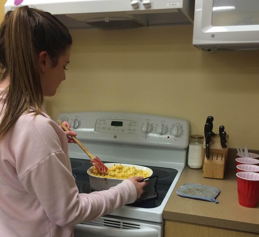 Independent living student Madison Stone stirs her piping hot pan of mac and cheese.