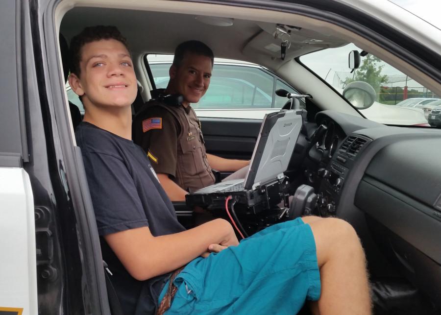 Deputy++Calimer+gives+John+Paul+a+look+inside+and+outside+his+police+car.+