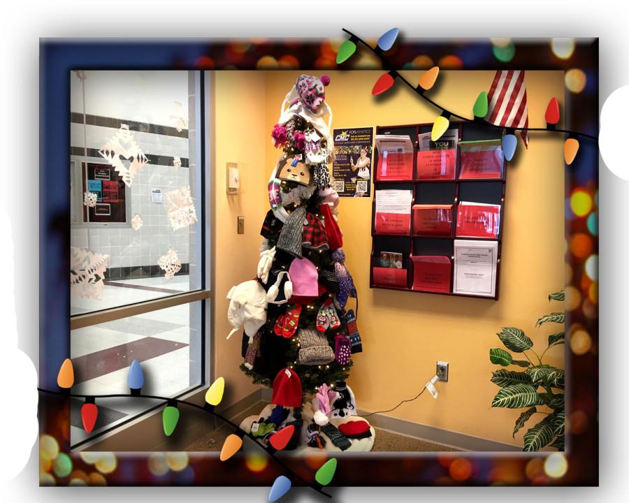 Warming the Lancer Spirit Holiday Drive Giving Tree, located in the front office.