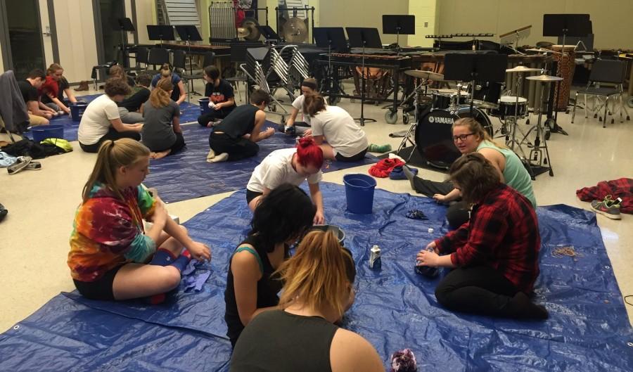 Color guard members Caitlyn Cook, Melissa Darling, Alida Hartwell, Payton Hull, Sophie Kirschner, and Diane Stonestreet tie-dye their flags for their show, Acceptance.