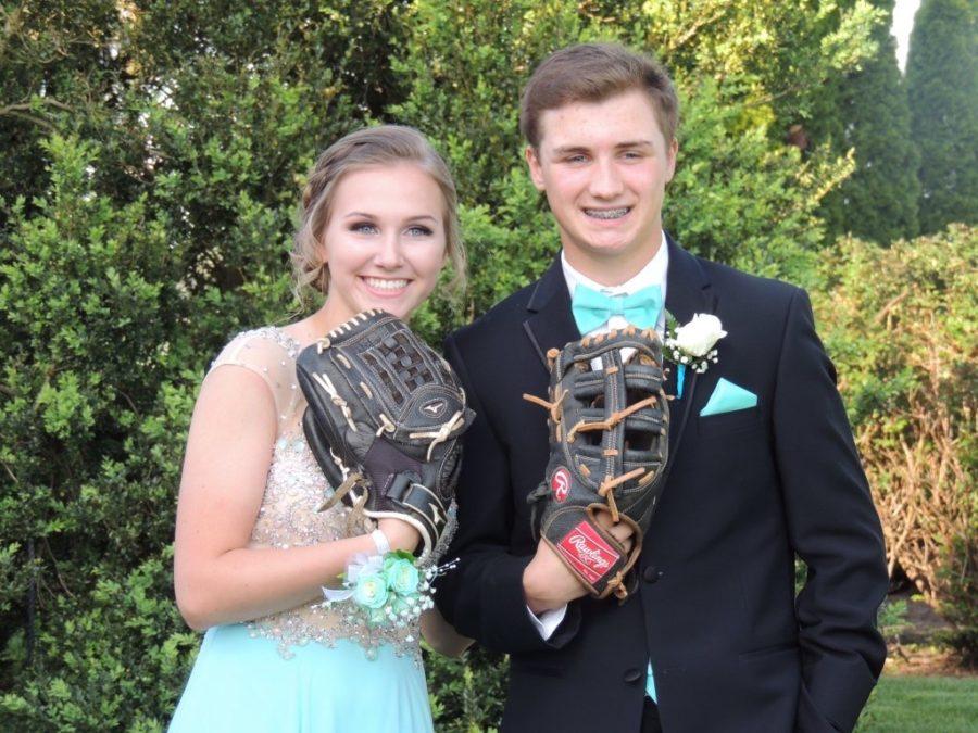 Junior Shelby Iager and sophomore Brett Tibbs pose with their mitts before prom