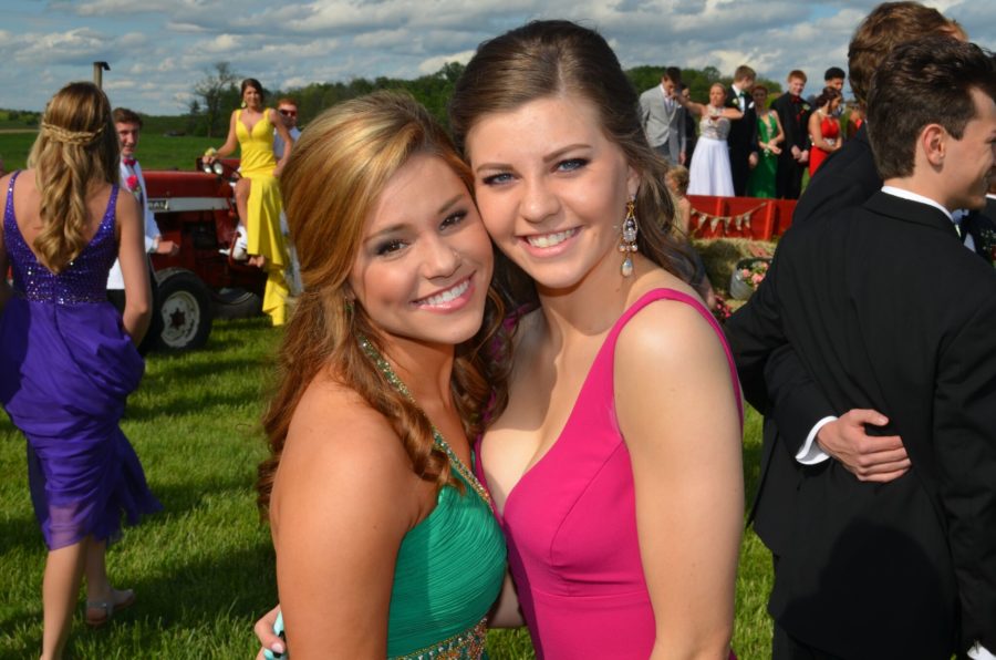 Seniors Olivia DuBro and Harper Lindsay smile amidst other prom-goers.