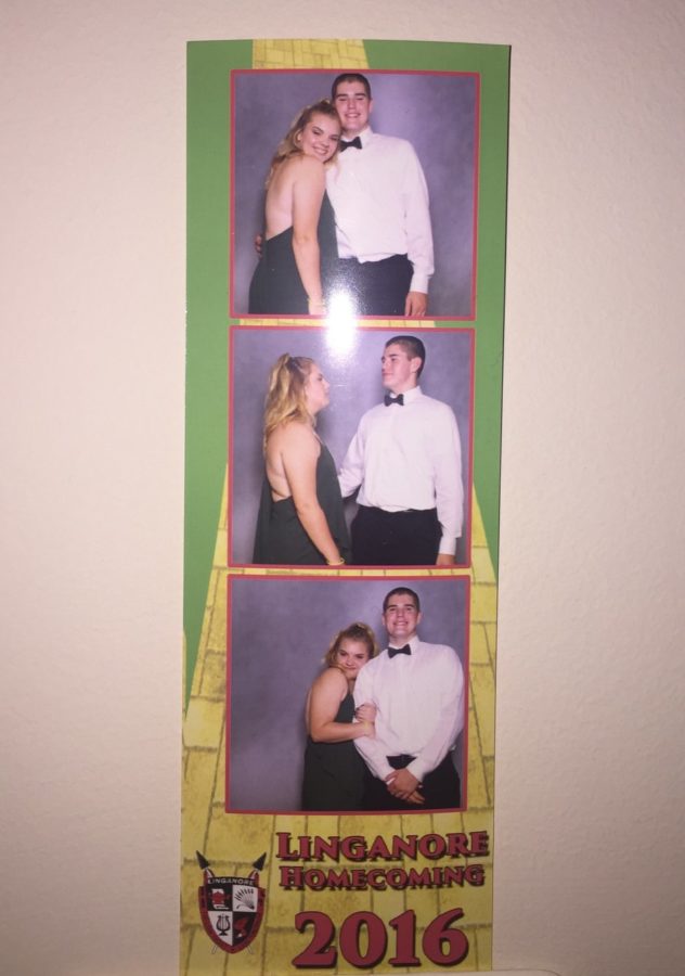 Class of 2017 members Melissa Darling and Kenny Thomas pose in front of the photo booth at homecoming.