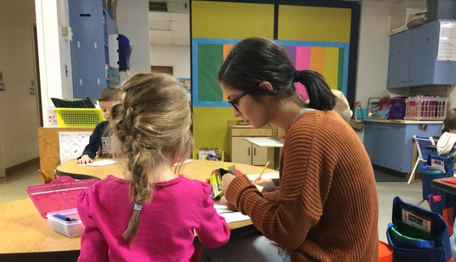 Alyssa Yammarino helps a kindergartner with writing.