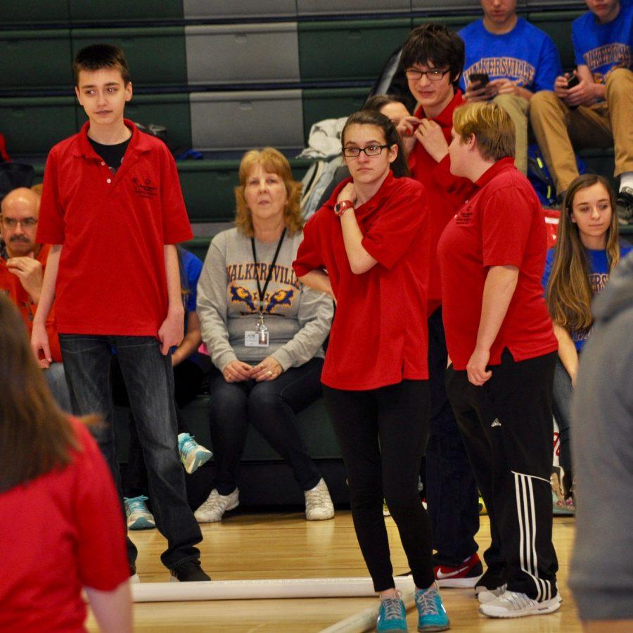 Watching the other side roll the bocce ball and hoping to earn points.