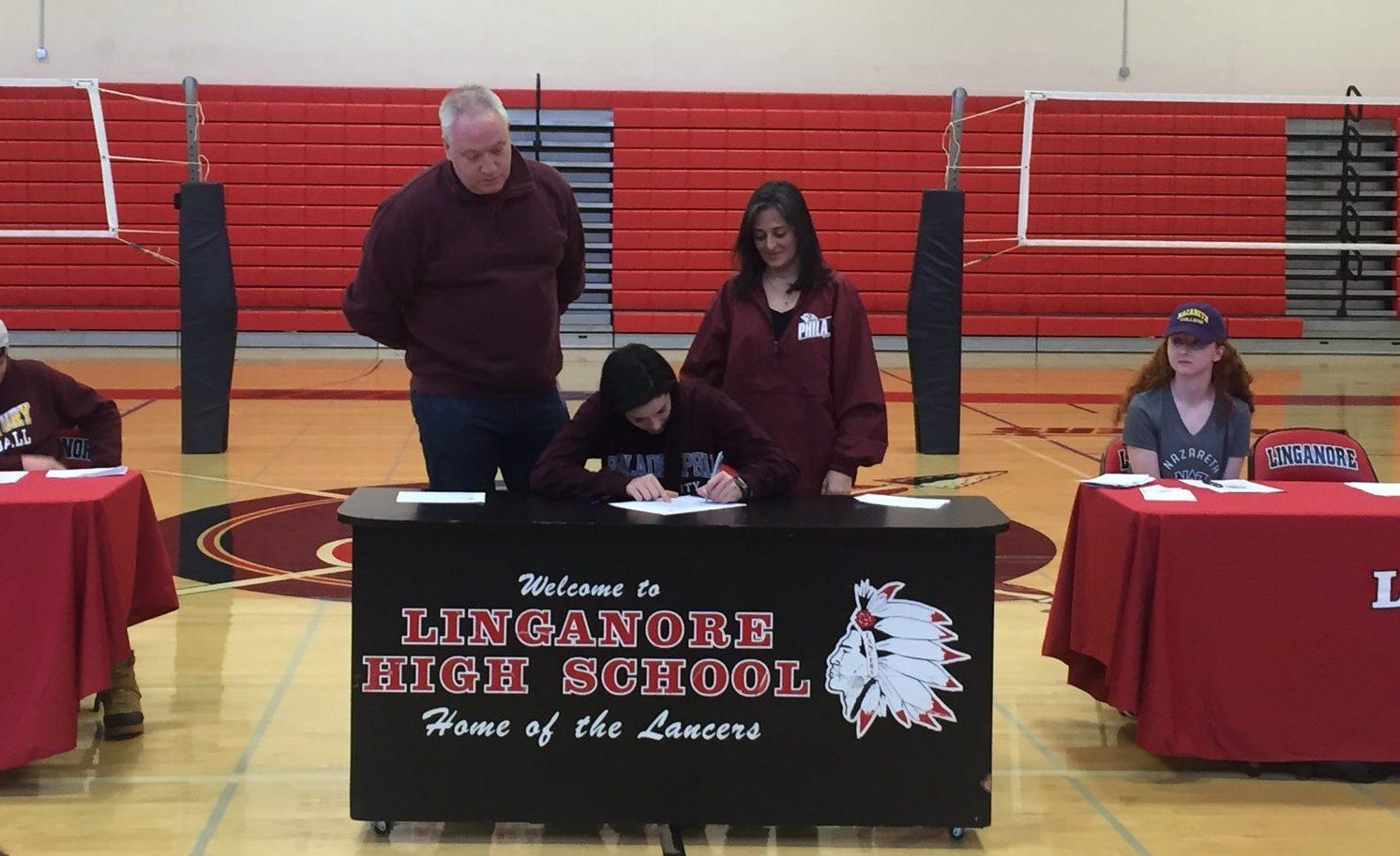 With her parents watching, Meredith Lapen signs her letter of intent to Philadelphia University. 