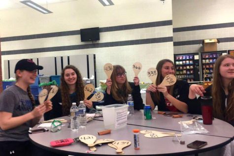 Members of the girls tennis team hold up their paddles during the fundraiser.