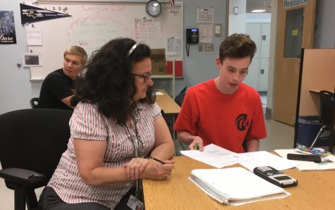 Mary Jo York assists Jake Bolger with his mathematics schoolwork.