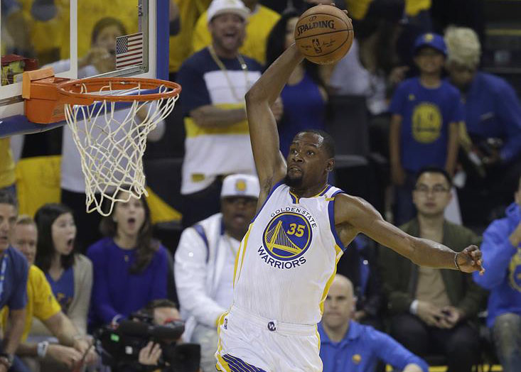 Golden State Warrior's Small Forward, Kevin Durant slam dunk the ball on an open basket.