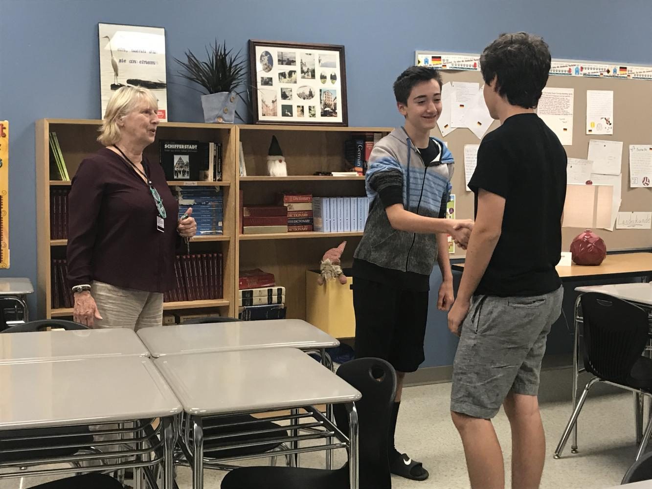 Mrs. Miller teaches German 1 students Max Loggins and Logan Damon how to greet each other in German.