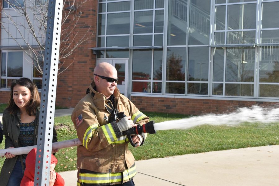 Firefighter shows the kids how to use a fireman hose. 