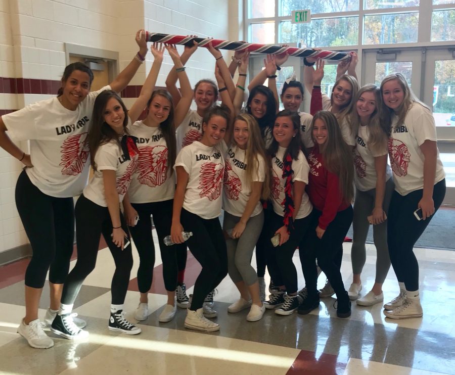 Lady Tribe holding the Spirit Stick after the pep rally on Red Black and Bow Day.
