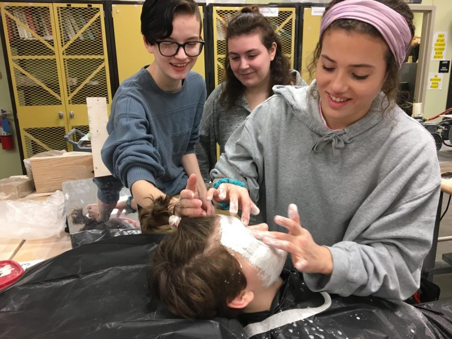 Mary Britton applies face casting to Natalie Roth with help from Kara Roth and Addison Clum. 