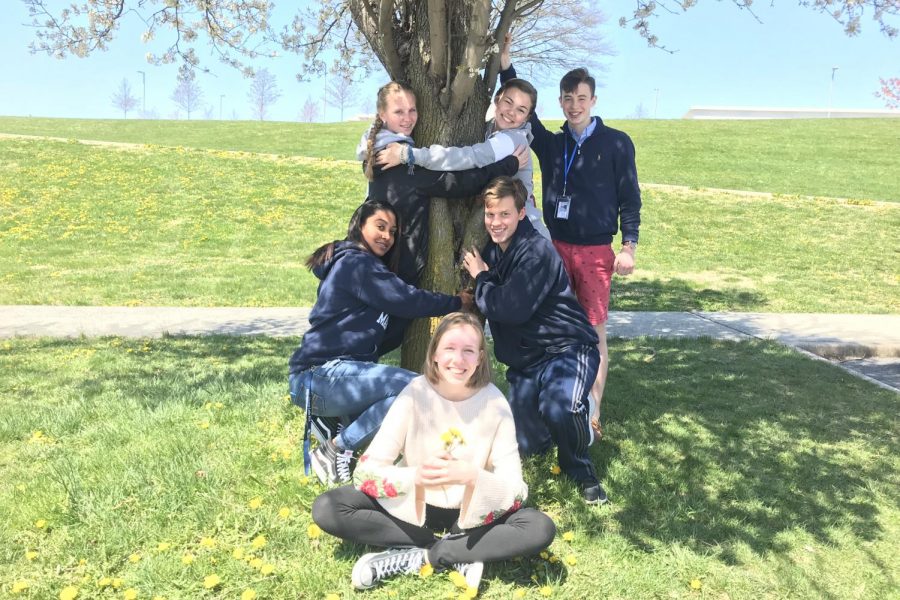 Journalism students show their love and enthusiasm for the environment by hugging a tree. 