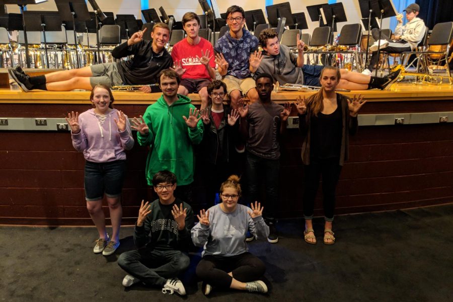 Andrew Nash, Matt Molineau, Richard Zhang, Evan Schalon, Mallory Safsten, Alex Pare, Erin Doyle, Charles Quansah, Olivia Weinel, Daniel Roberson, and Allie Hudson pose in front of the stage during symphonic band practice