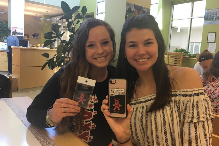 Emily Wolfe and Rachel Morin pose with their Lancers Against Cancer phone wallets. 