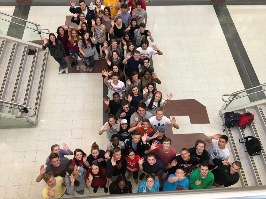 Class of 2018 members make the shape of a 1 in honor of their last day.