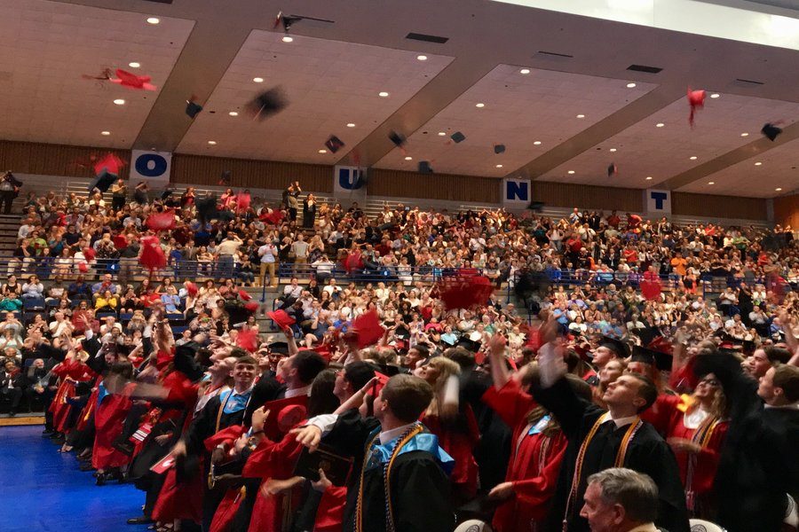 Class of 2018 graduates throw their caps.