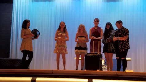 Rozmia Fattah, Katie Thomas, Cassidee Grunwald, Hannah Haught, and Shayden Jamison laugh while performing on stage together during final senior performances.