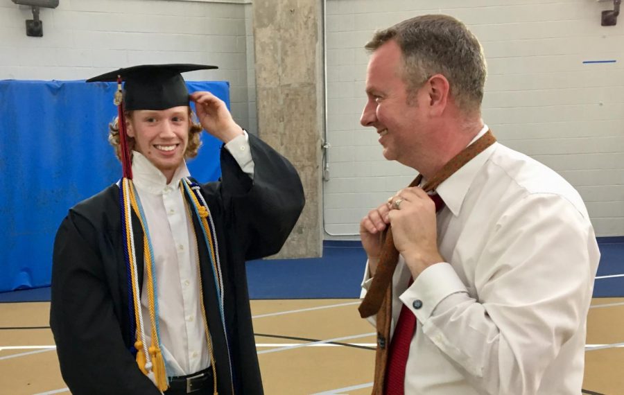 Mr. McWilliams teaches Luke Fay how to tie his tie before graduation. 