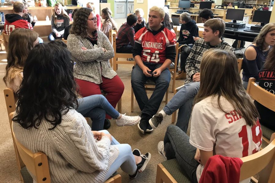 Students and staff converse in small groups over school and political issues.