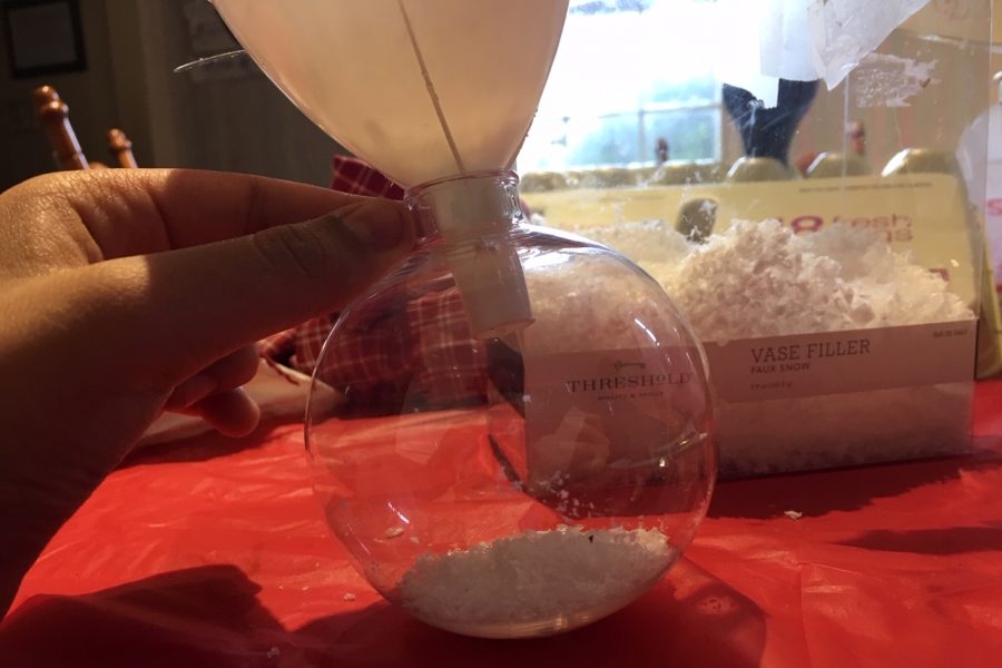 Use the funnel to put the fake snow into the ornament