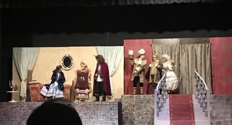 The Beast (David Kominars) tries to persuade Belle (Mackenzie Berry) to come to dinner. Madame de la Grande Bouche, Lumiere, Cogsworth and Mrs. Potts look on.