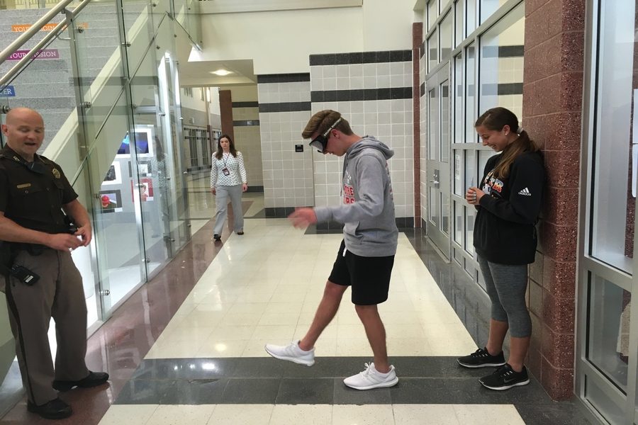Junior Bailey Spore attempts to walk in a straight line while wearing the drunk goggles as Deputy Mostoller observes. 