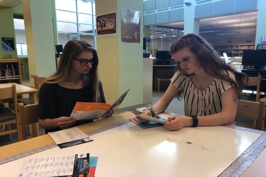 Class of 2020 members Alexis Fowler and Emily Webb read information about the FCPL Summer Reading Challenge.