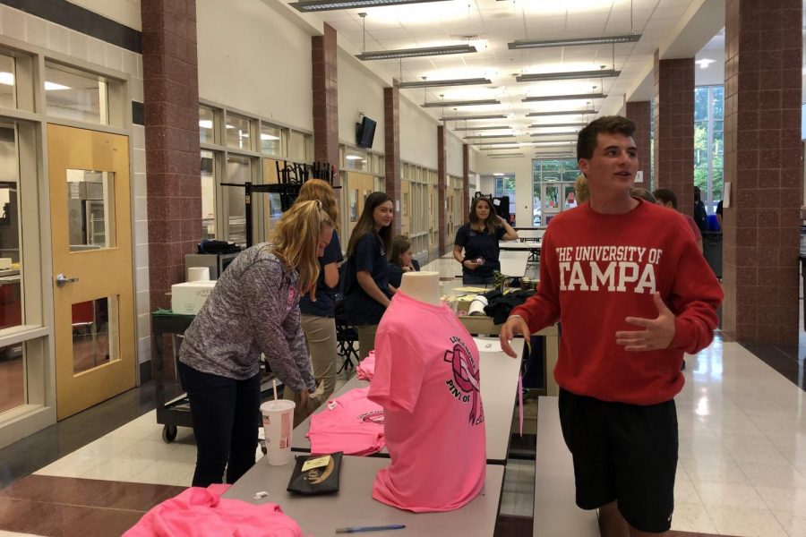 Taylor Ferguson sells a pink out shirt to Billy Higgins