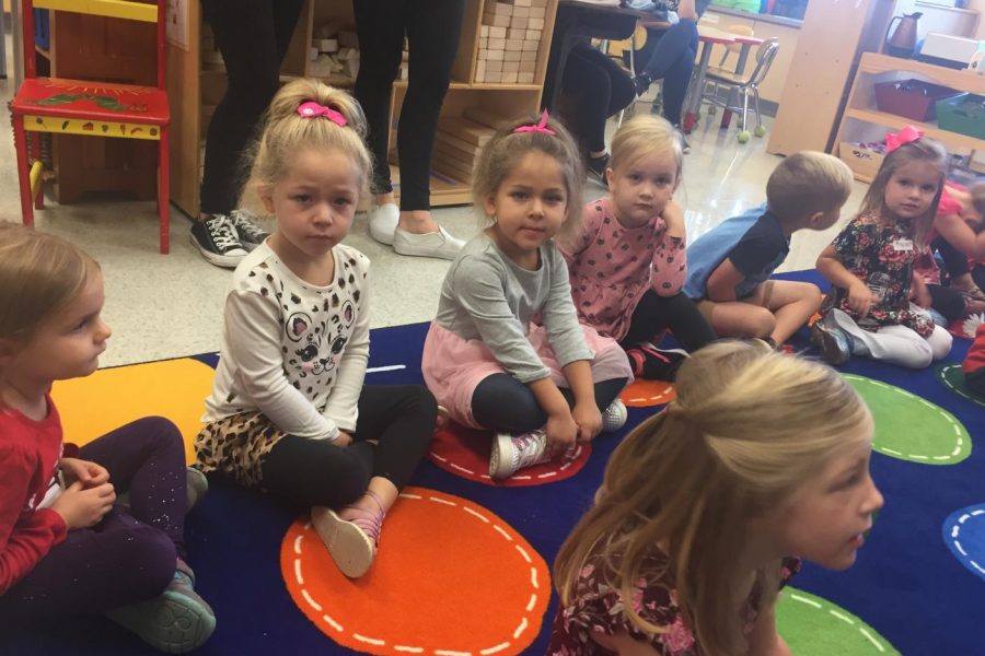 The Little Lancers sit on the carpet and wait for directions from the student teachers.