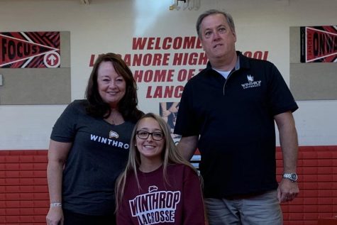 Cassie Nalepa poses for a photo with her parents after signing her National Letter of Intent.