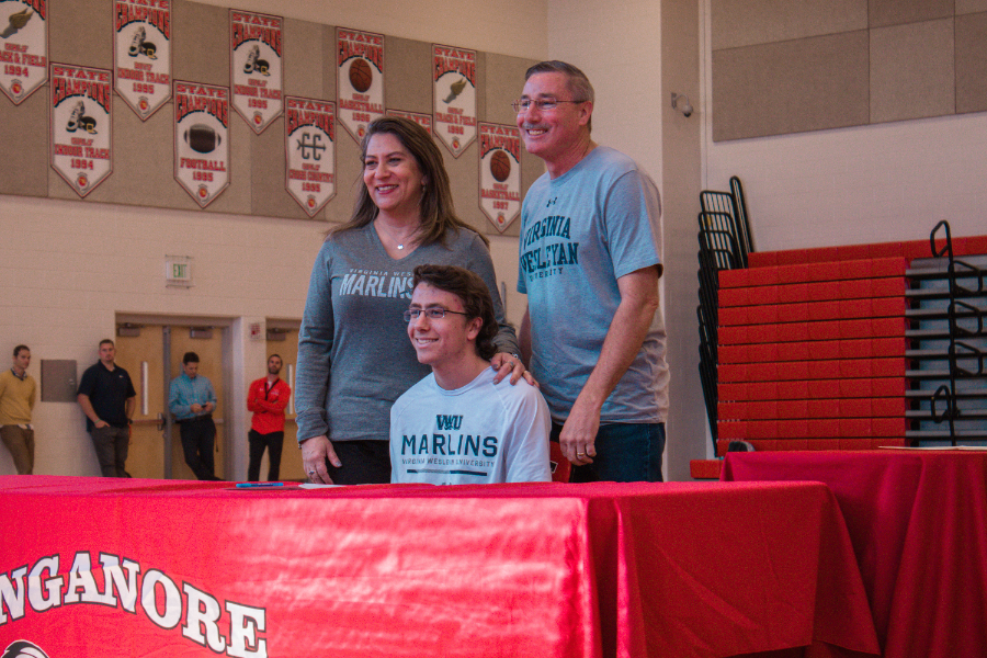 Aaron Oman poses with his parents after signing his National Letter of Intent.