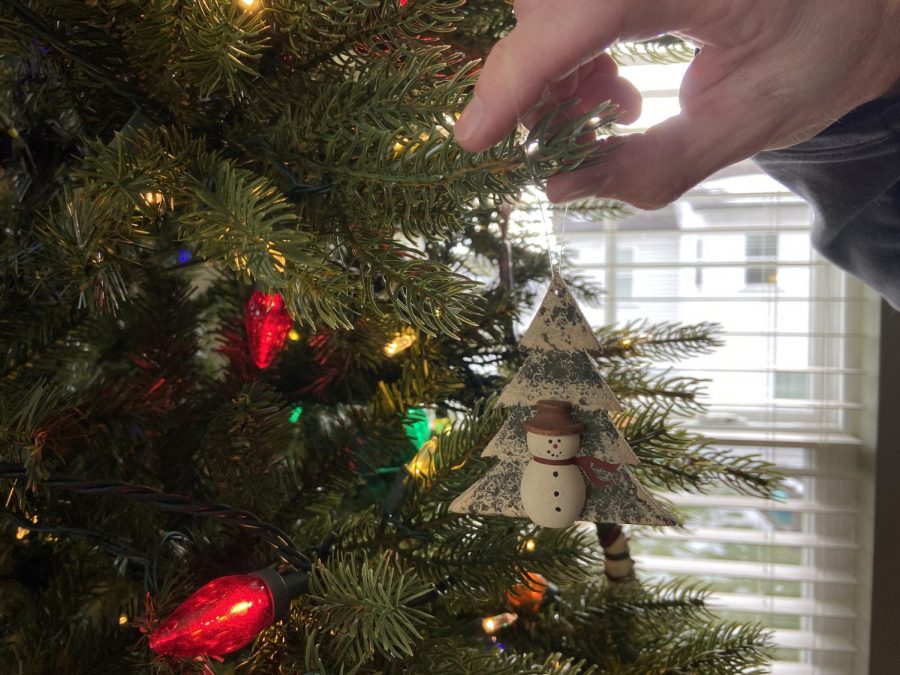 Ken Spore hangs ornaments on family Christmas tree.