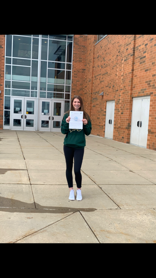 Hill holding her National Letter of Intent outside Linganore gymnasium. 